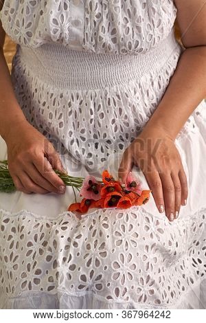 Woman In White Dress Holding Poppe Flowers, Close Up On Her Hands. Spring Time Dreams.