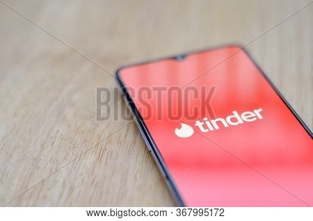 New York, Usa, 2020. Flat Lay With Wooden Background And Tinder App Logo On Display On A Smartphone 