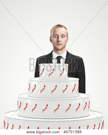 Businessman looking at the cake. Concept of a prize.