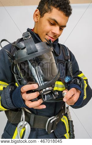 Full Protective Breathing Air Mask In Hand Of Unrecognizing African American Firefighter, Rescue And