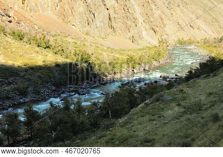 A Stormy Stream Of A Swift River In The Shadow Of The Mountains Of The Setting Sun On A Warm Autumn
