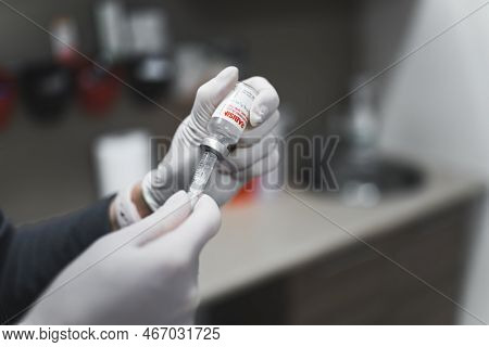 11.27.2022 Warsaw, Poland. Unrecognizable Vet In Protective White Gloves Using Syringe And Needle To
