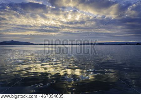 Sunrise Landscape Of Lake Zugersee In The Swiss Town Of Zug, Calm With Blue Sky With Clouds.