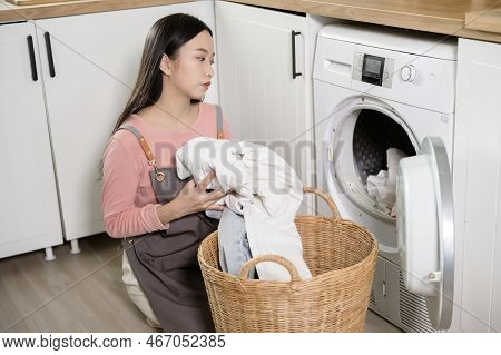 Exhausted  Asian Young Woman With Dirty Clothes , Doing Laundry In Home