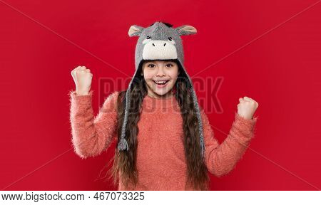 Successful Teen Child Model In Earflap Hat. Teen Child In Earflap Hat Isolated On Red Background.