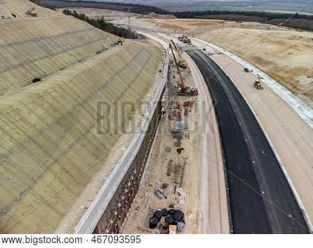 Mountain Road Constraction. Workers Reinforce The Slope Over The New Road. Road Construction In Prog