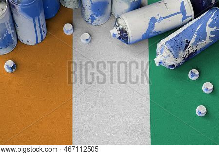 Ivory Coast Flag And Few Used Aerosol Spray Cans For Graffiti Painting. Street Art Culture Concept, 