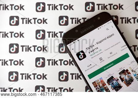 Ternopil, Ukraine - May 2, 2022: Tik Tok Smartphone App On Screen And Many Tiktok Logo Printed On Pa