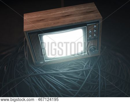 An Illuminated Vintage 80's Television Perched On A Jumbled Pile Of Black Cables On A Dark Omnious B