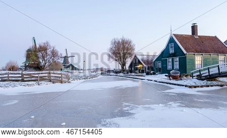 Zaanse Schans Windmill Village During Winter With Snow Landscape In The Netherlands At Sunrise