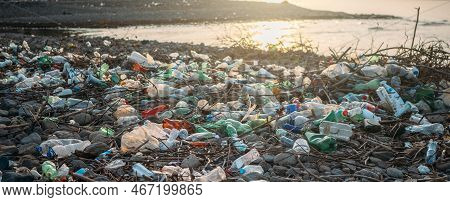 Stone Beach With Plastic Waste. Plastic Bottles In Nature. Environmental Pollution Concept.
