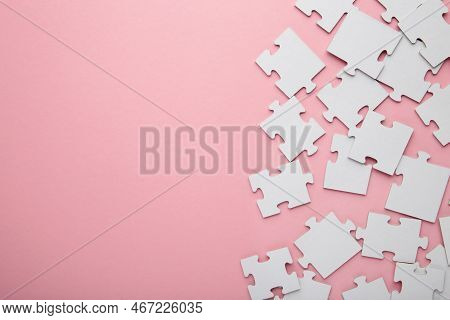 Uncompleted Elements Of A White Puzzle On Pink Background. Space For Text. Top View