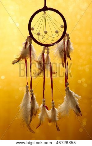 Beautiful dream catcher on yellow background with lights