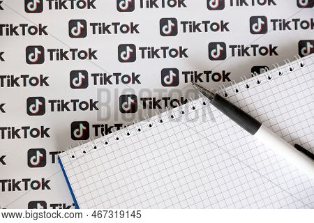 Ternopil, Ukraine - May 2, 2022: Notepad With Pen And Many Tiktok Logo Printed On Paper. Tiktok Or D