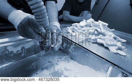 Mane Taking Out Models From White Polyamide Powder In Working Chamber Of 3d Printer, Cleaning And Re
