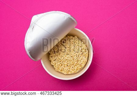 Opened Package With Uncooked Instant Noodles On Pink Background. Raw Pasta. Dry Asian Fast Food. Qui