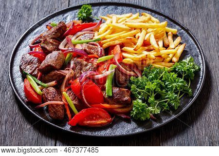 Lomo Saltado, Peruvian Dish Of Stir-fried Slices Of Beef Sirloin, Onions, Yellow Peruvian Chilis, An