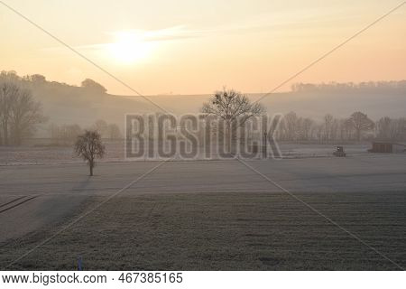 Sunrise On A Frozen Morning With A Little Fog And White Fields