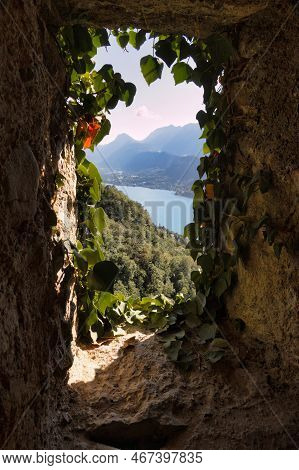 Talloires, France - September 09 2021 : Window With Ivy Made In Cave Stones By Monks With Mountain V
