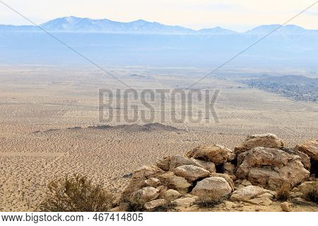 Sandstone Rocks On A Mountain Ridge Overlooking The Vast Mojave Desert With The San Gabriel Mountain