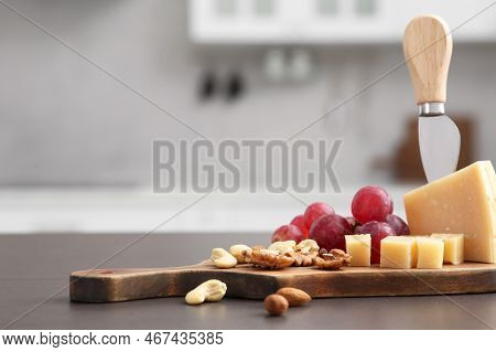 Wooden Bord With Cut Cheese And, Nuts And Grape On Countertop In Kitchen, Space For Text