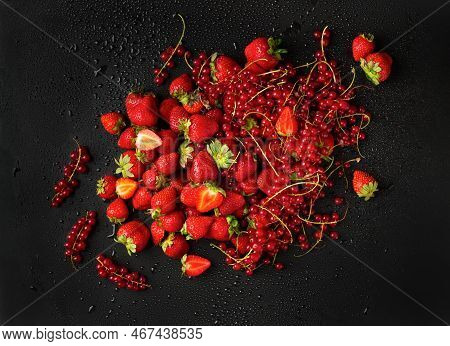 Strawberries And Red Currants On A Dark Background. Sprigs Of Red Currant And Strawberries With Gree