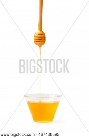 Honey In A Bowl With Honey Flowing From A Spoon On A White Background. Honey With Honey Dipper Isola