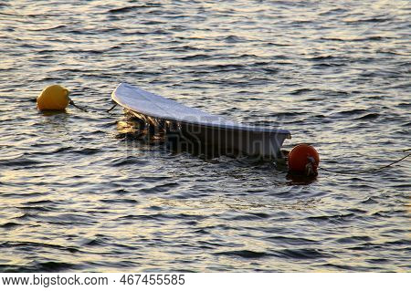 A Paddle Board Floating In The Water During Sunset.