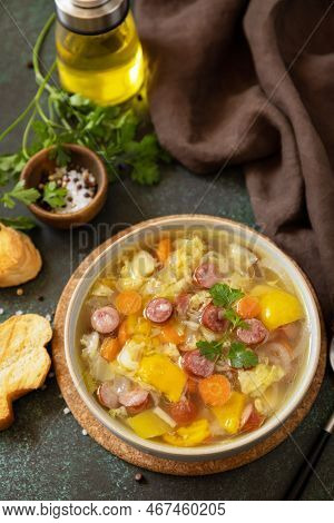 Traditional Zelnacka Cabbage Soup With Sausages And Vegetables In A Bowl On A Stone Tabletop. Czech