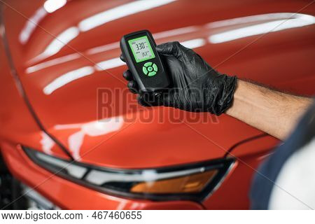Closeup View Of Male Hand, Using Film Coating Thickness Gauge Device To Check Car Paint. Auto Coatin