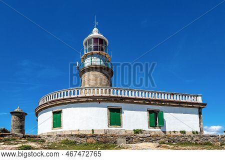 Corrubedo Lighthouse In The Atlantic Ocean, Galicia, Spain. Lighthouse On Top Of A Rock Crag For Saf