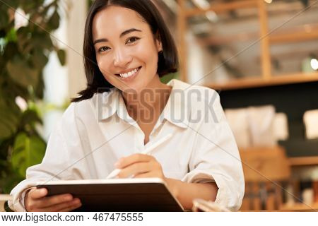 Portrait Of Asian Girl Drawing On Digital Tablet, Scatching And Doodling With Graphic Pen, Sitting I
