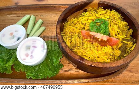 Rice Lamb Biryani Pilaf With Lamb Or Mutton Meat And Vegetables Cucumber Along With Yoghurt In A Ver