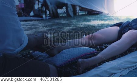Male Masseur Massages The Legs In A Beautiful White Ornamrental Tent.