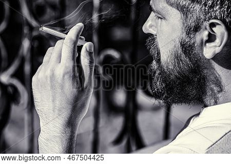 Smoking Man With Beard. Young Hipster Man Smokes. Black And White