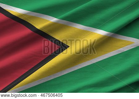 Guyana Flag With Big Folds Waving Close Up Under The Studio Light Indoors. The Official Symbols And 
