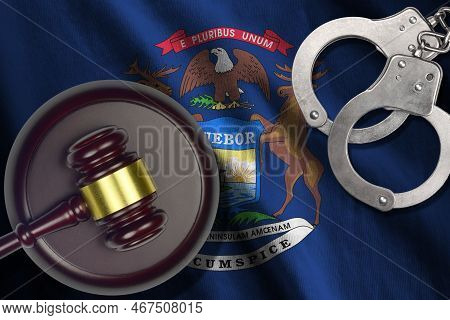 Michigan Us State Flag With Judge Mallet And Handcuffs In Dark Room. Concept Of Criminal And Punishm