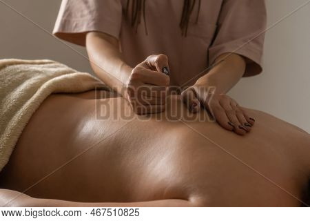 Close-up Of The Masseur's Hands Doing A Back Massage To A Woman In The Salon In A Cozy Atmosphere. C