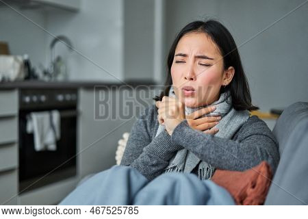 Sick Korean Woman Coughing And Feeling Unwell, Grimacing, Has Influenza, Cought Cold Or Flu, Staying