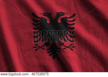 Albania Flag With Big Folds Waving Close Up Under The Studio Light Indoors. The Official Symbols And