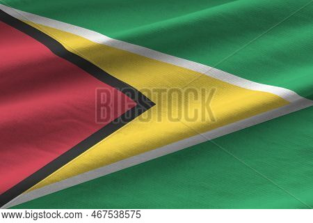 Guyana Flag With Big Folds Waving Close Up Under The Studio Light Indoors. The Official Symbols And 