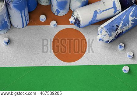 Niger Flag And Few Used Aerosol Spray Cans For Graffiti Painting. Street Art Culture Concept, Vandal