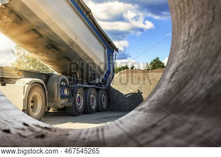 A Large Dump Truck Unloads Rubble Or Gravel At A Construction Site. Car Tonar For Transportation Of 