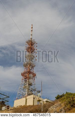 Communications Tower Under Cloudy Sky.