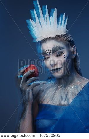 Glad Ice Queen With Apple Against Blue Background