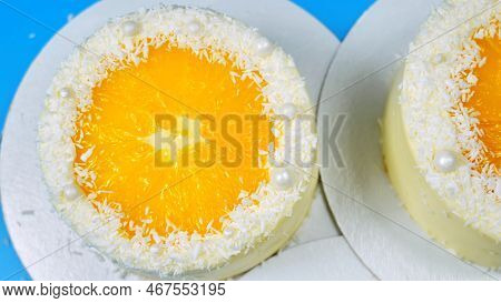 Small Cakes With Orange And Coconut On A Blue Background.