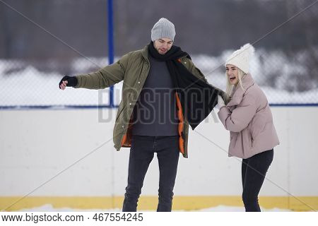 Sports And Lifestyle. Young Caucasian Couple In Winter With Ice Skates Posing Together Over A Snowy