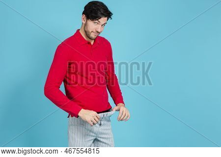 One Smiling Caucasian Handsome Brunet Man In Striped Underware Pulling Pants While Looking Aside Aga