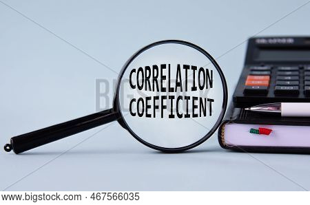 Correlation Coefficient - Words On Magnifying Glass On A Light Background With Calculator, Notepad A