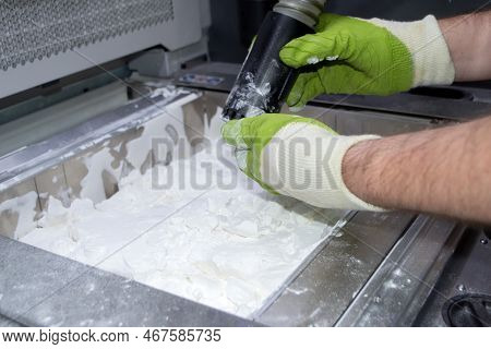 Mane Taking Out Models From White Polyamide Powder In Working Chamber Of 3d Printer, Cleaning And Re